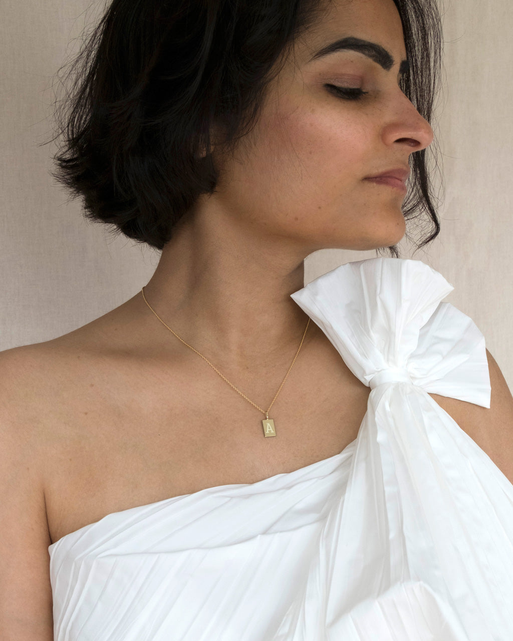 Indische Frau trägt Goldkette mit Buchstaben