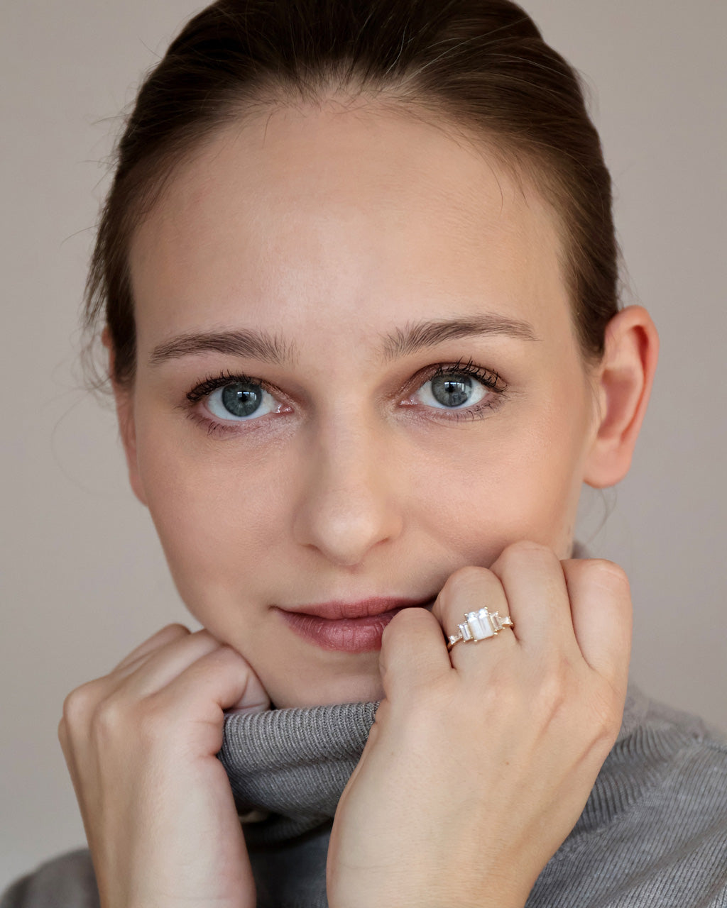 frau trägt verlobungsring in Gold mit Edelsteinen